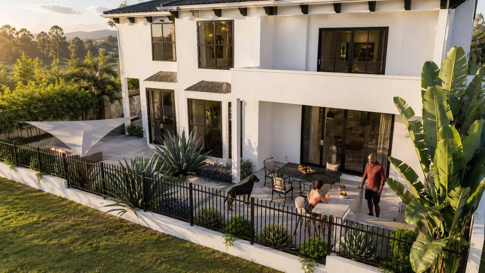 Rear outdoor gathering space with built-in seating, fire feature, landscape lighting, and neighborhood views.