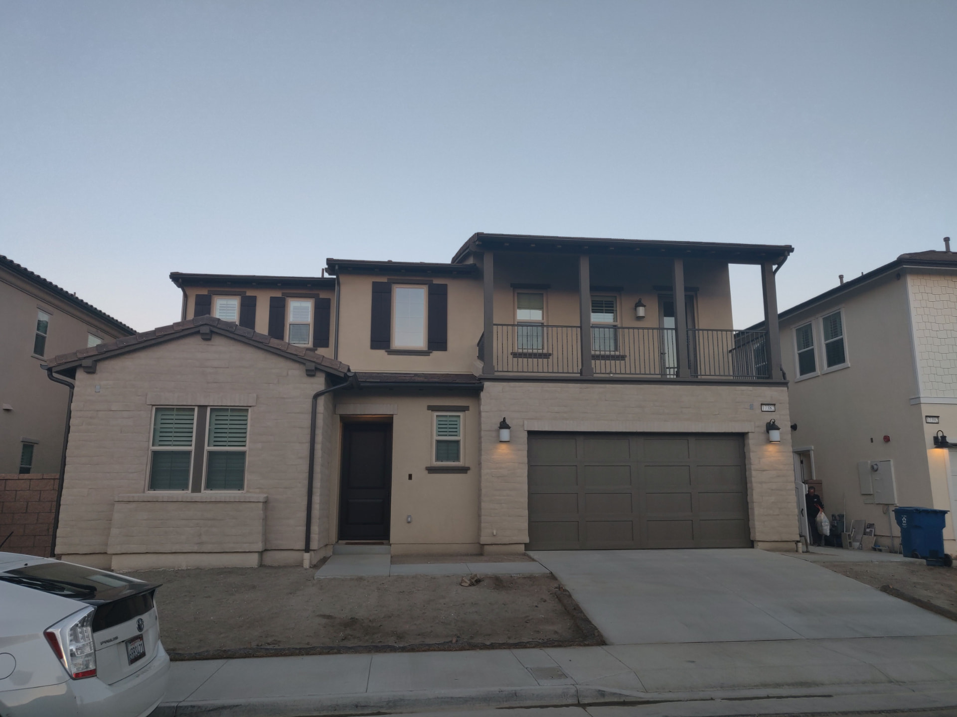 Existing condition photograph of a new tract home front yard in Huntington Beach with bare dirt, no planting, and an unfinished walkway.