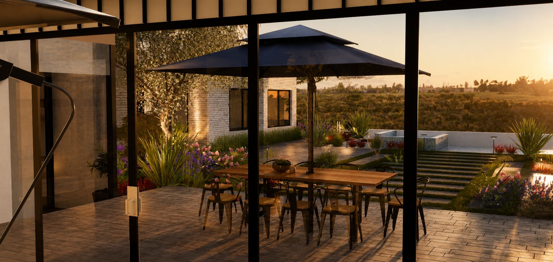 View through glass doors toward an outdoor dining area, pool, landscape planting, and sunset at Newport Beach View Estate.